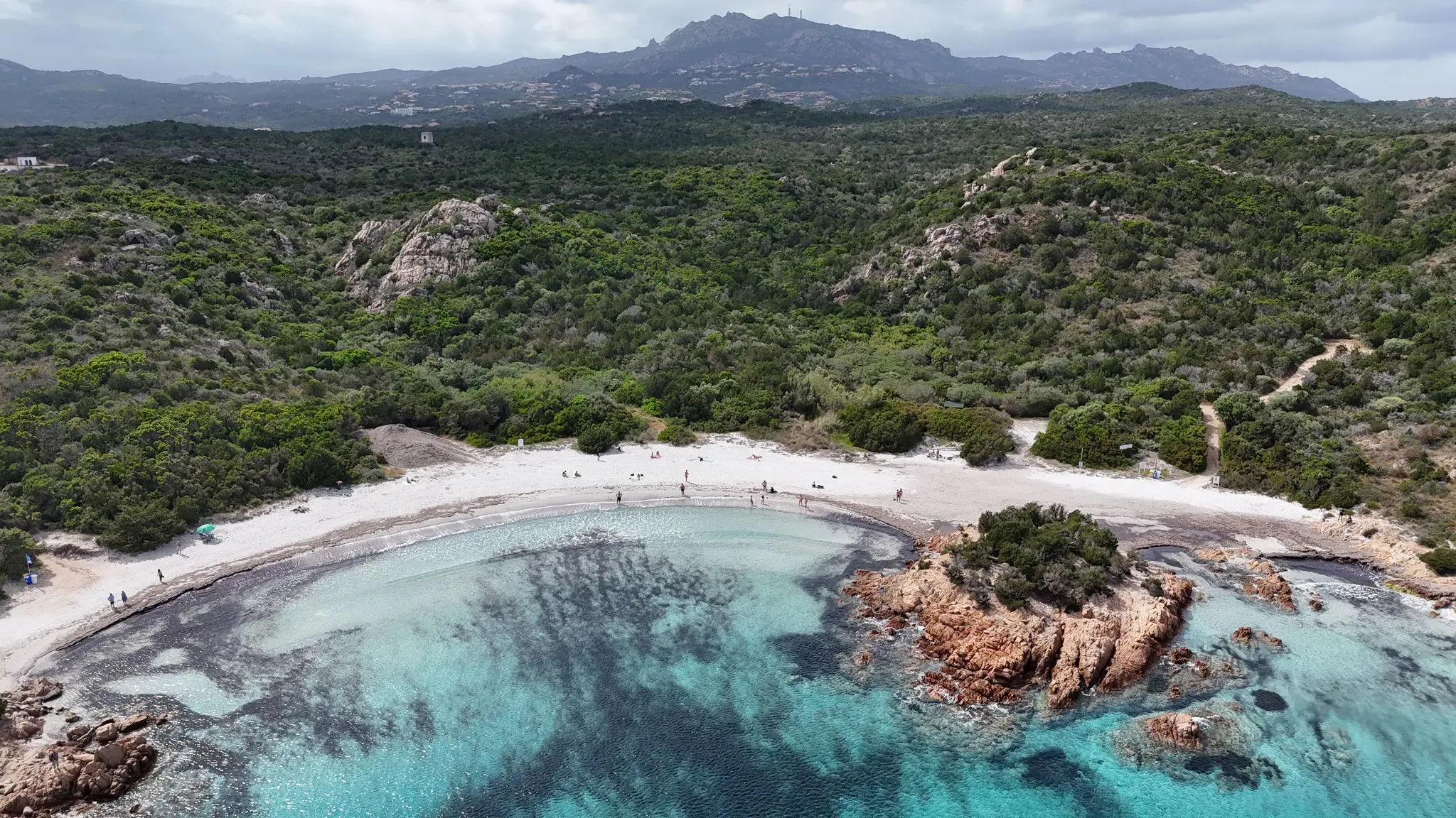 vue aérienne d'une plage de sable blanc aux eaux turquoise et cristallines
