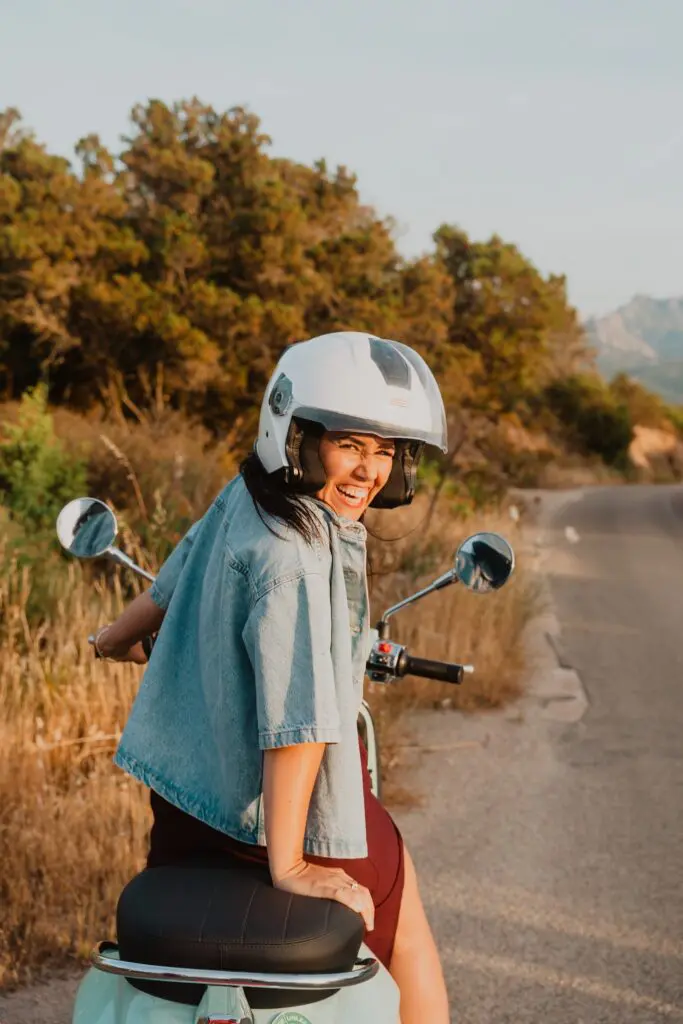 femme casquée sur un scooter, sur une route en Sardaigne