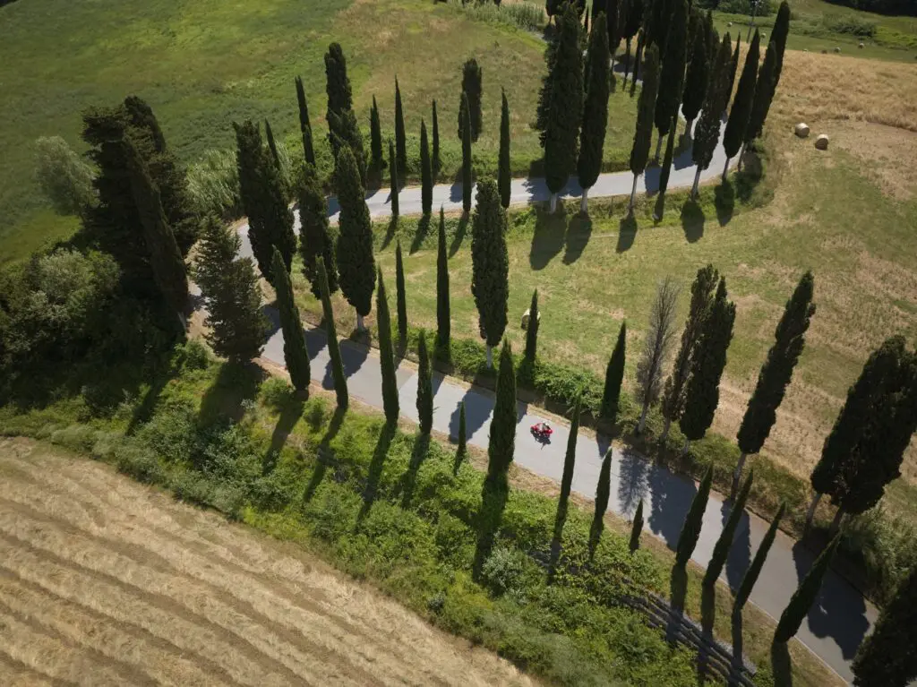 prise de vue aérienne d’un scooter rouge sur une route sinueuse en Toscane