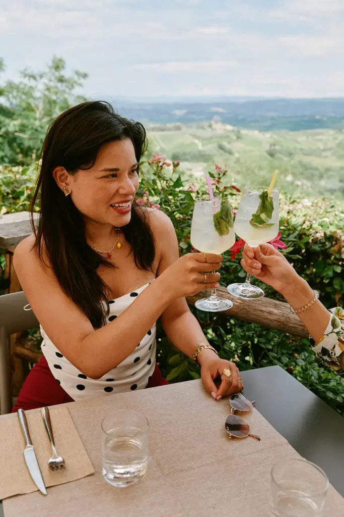 Deux femmes trinquant sur une terrasse avec vue sur la Toscane
