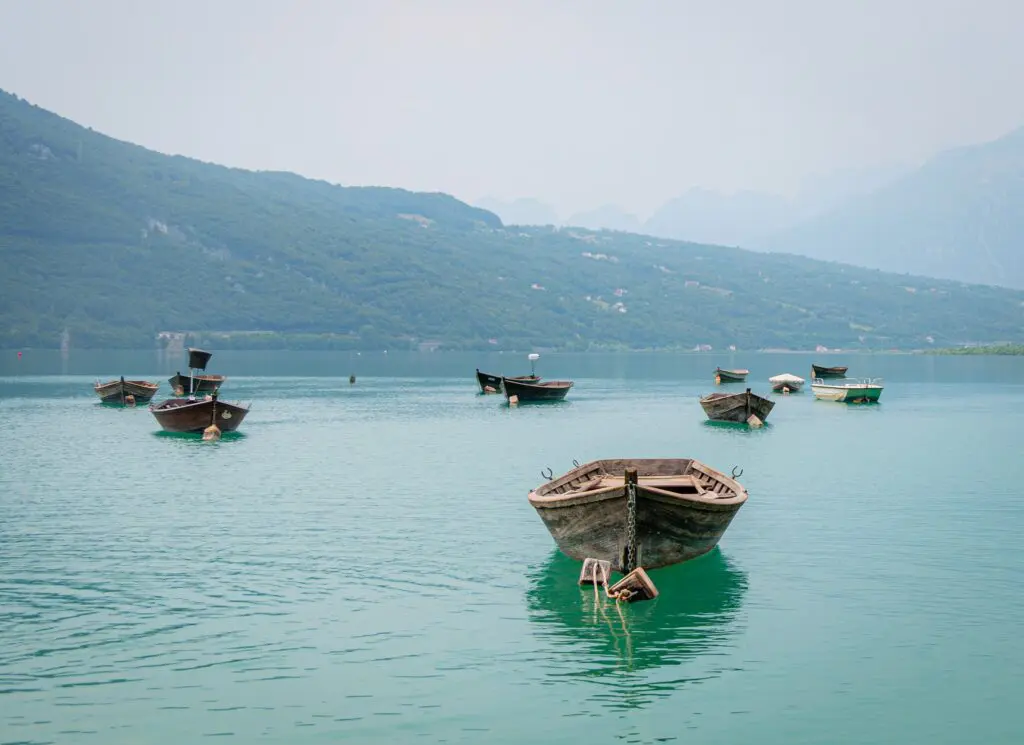 barques en bois flottant sur un lac turquoise entouré de montagnes
