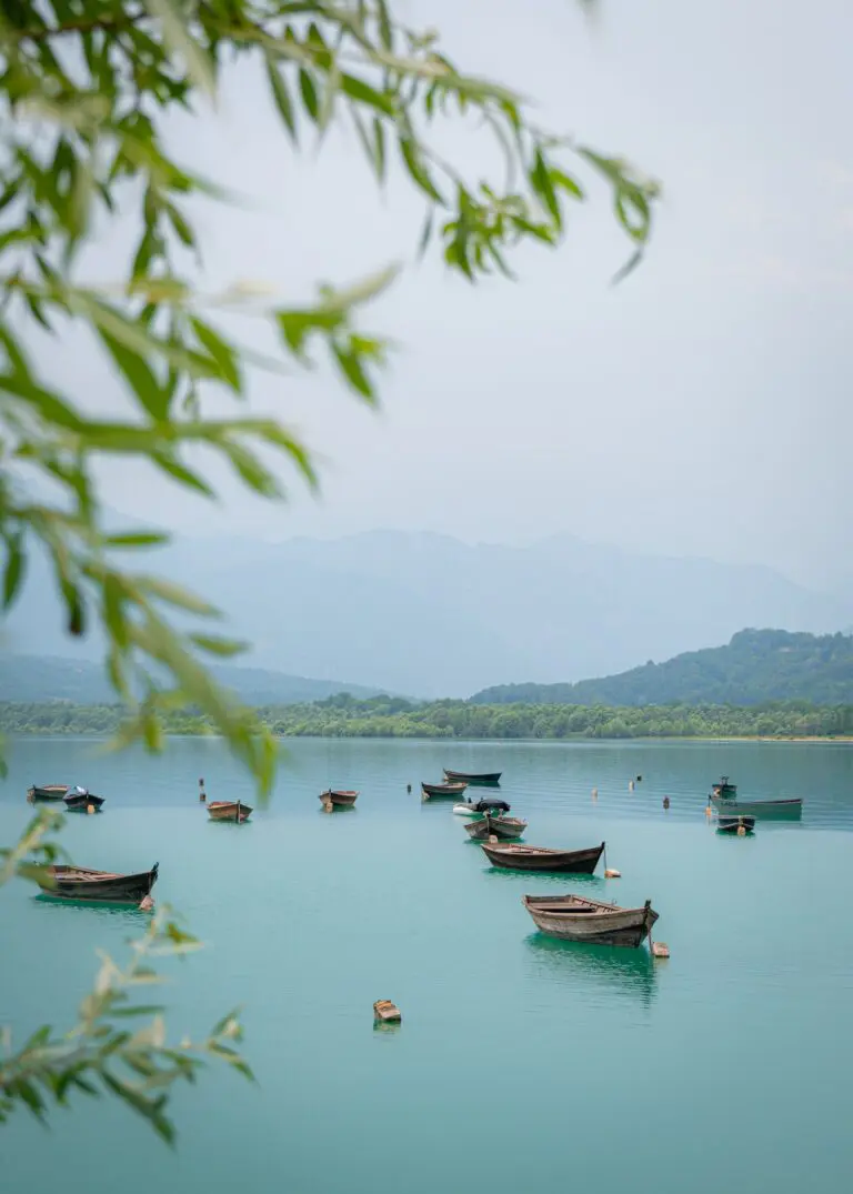 barques en bois sur un lac turquoise entouré de montagnes et d'arbres
