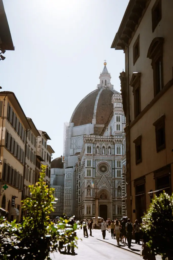 Dôme de Florence encadré par des bâtiments, avec des passants