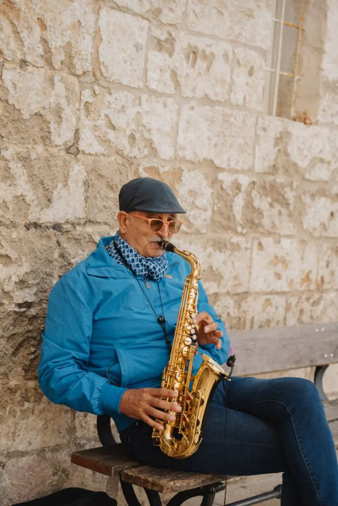 homme jouant du saxophone sur un banc dans les Pouilles
