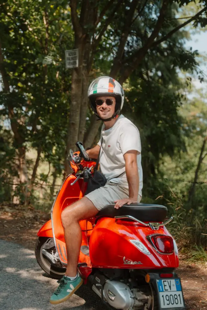 Homme sur un scooter Vespa rouge en Vénétie, en Italie