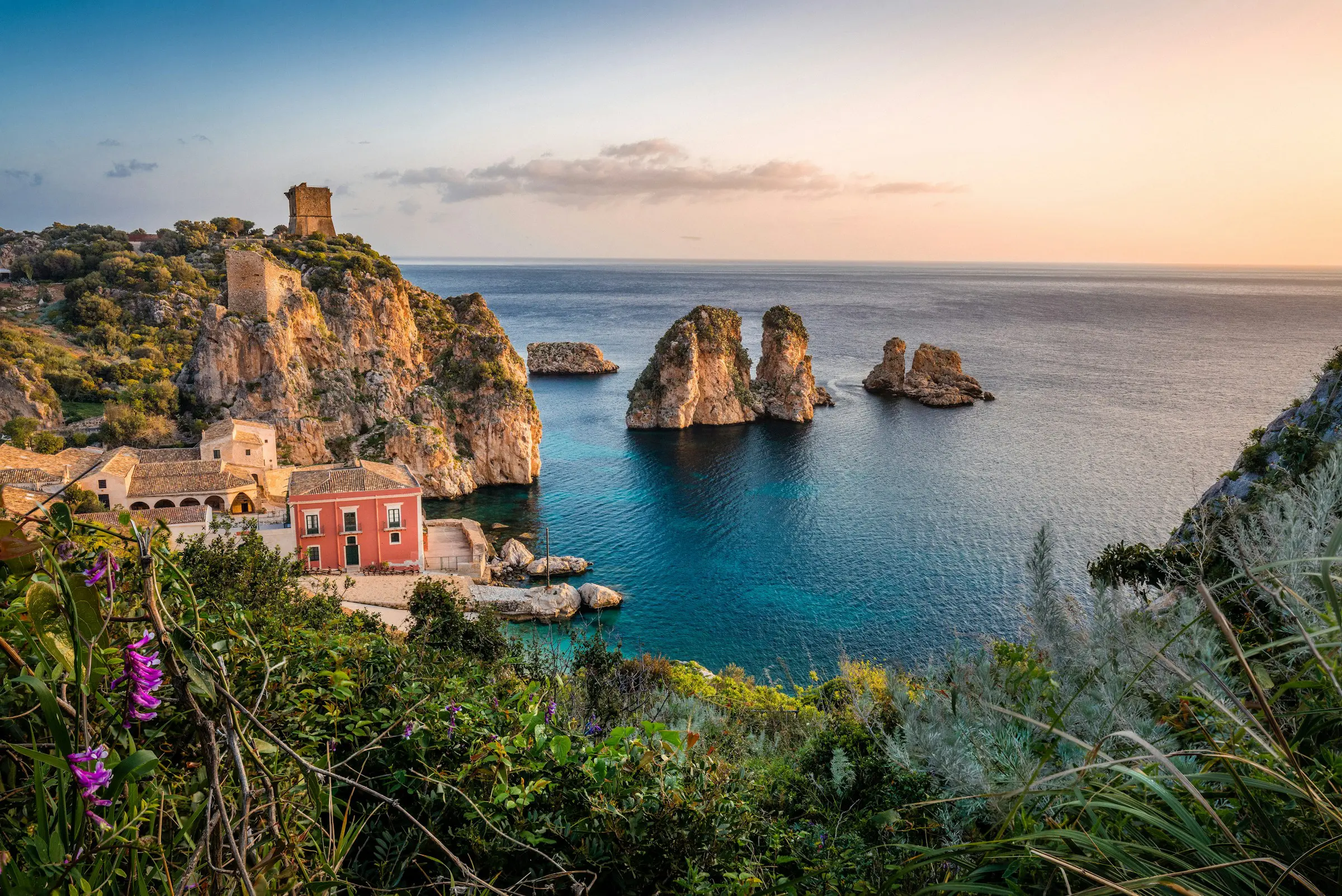 photo d'une maison près d'une falaise et d'une étendue d'eau