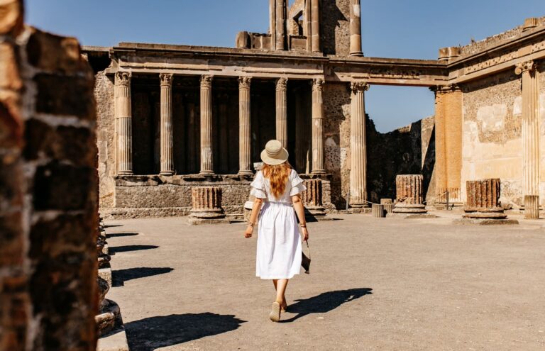 femme en robe blanche marchant dans les ruines antiques de Pompéi