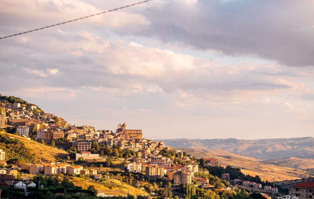 hilltop village in Sicily at sunset with rolling hills